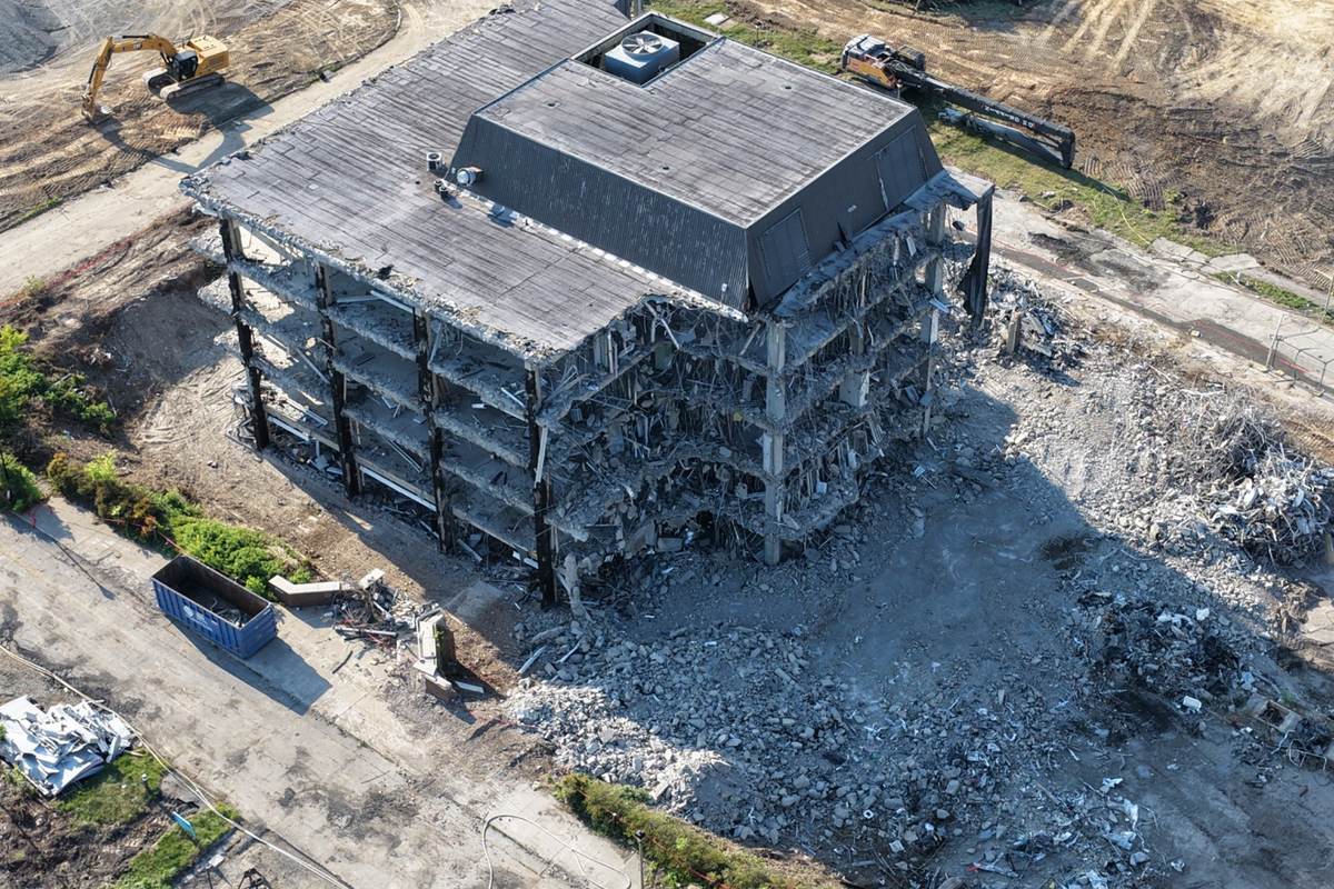 Close aerial demolition progress photo showing debris piles, partial structure removal, and site condition records