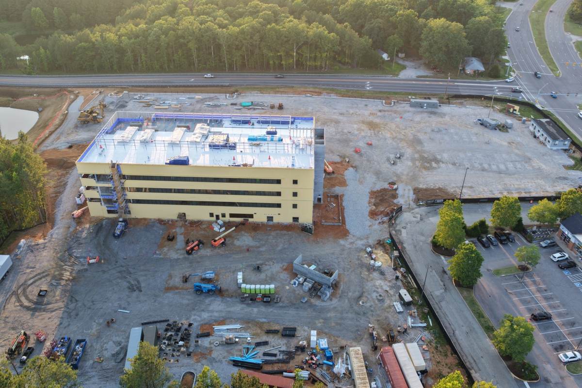 Full lot aerial healthcare construction documentation with staging, access roads, and exterior progress